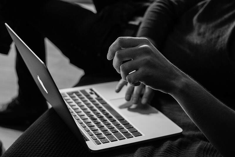 Hände tippen auf Laptop